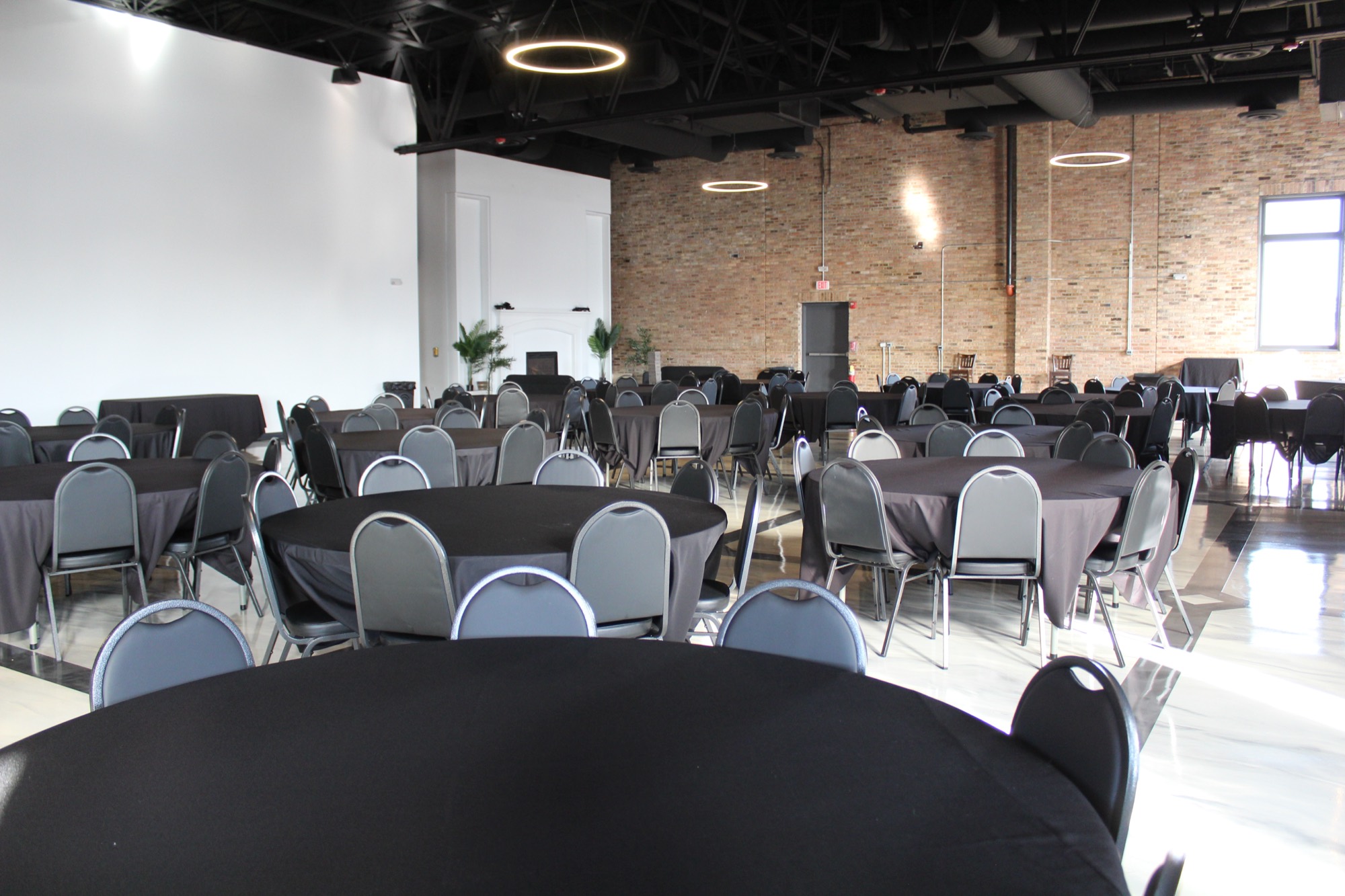 Round banquet tables set with black linens in the main hall